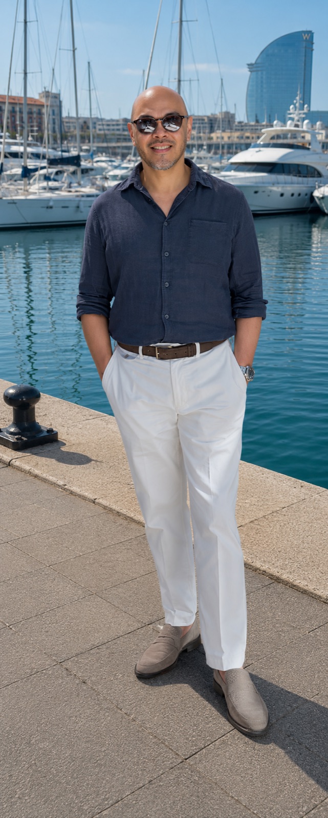 Lee standing on the marina boardwalk in Barcelona with yachts moored behind him