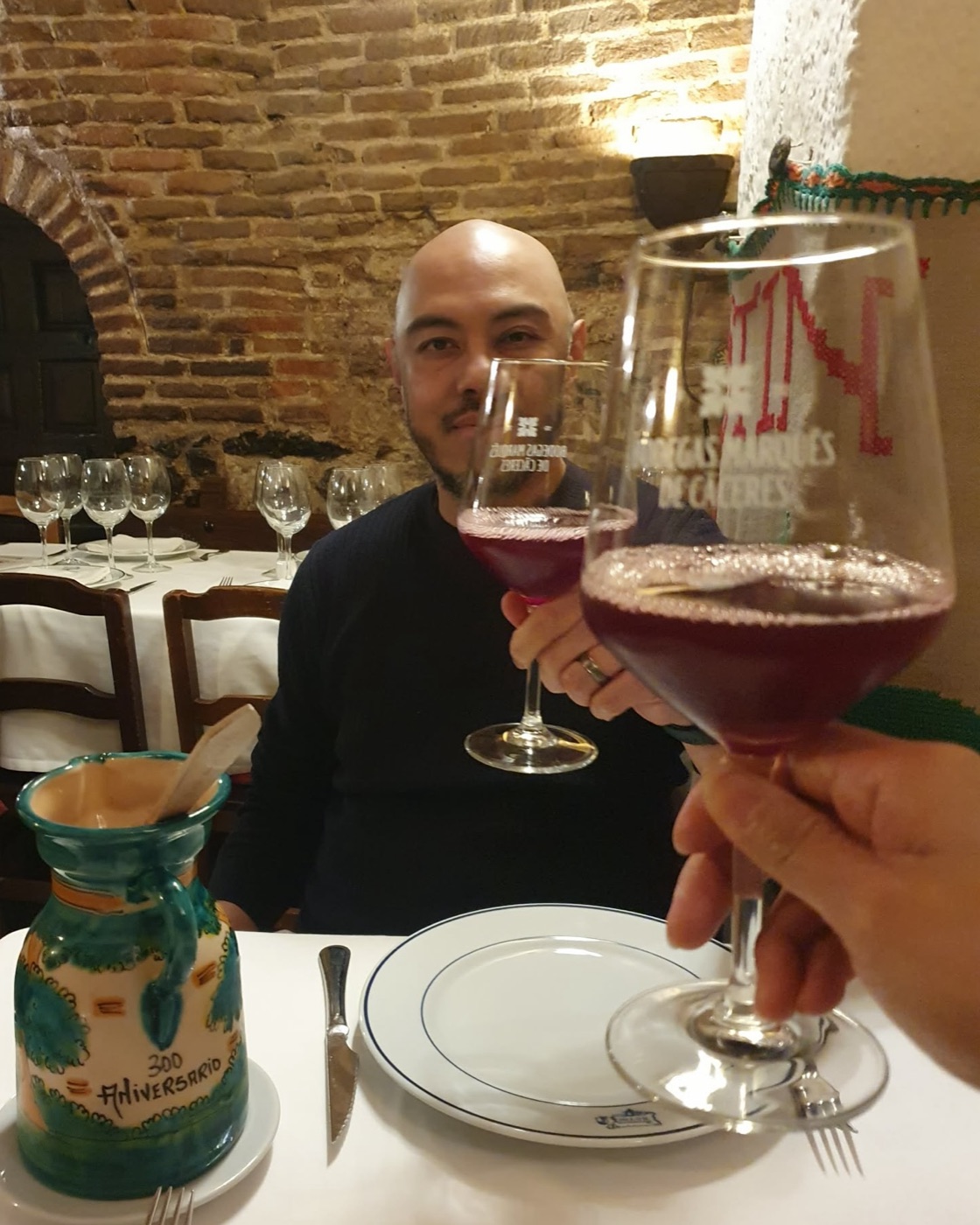 Lee raising a glass of wine at a restaurant table