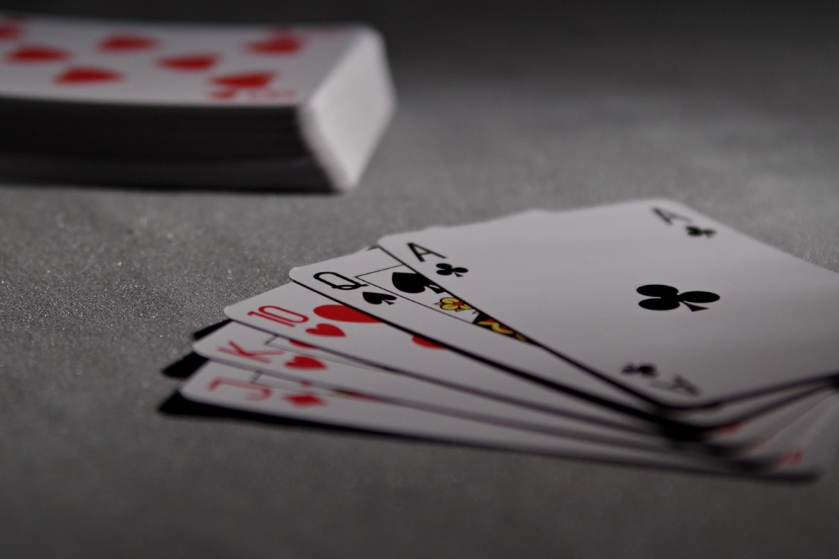 A fanned hand of playing cards on a gray table